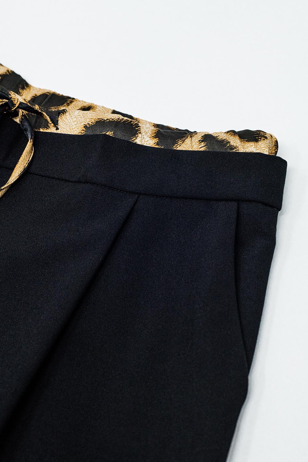 Pantal&oacute;n largo negro plisado con detalle de leopardo en la cintura