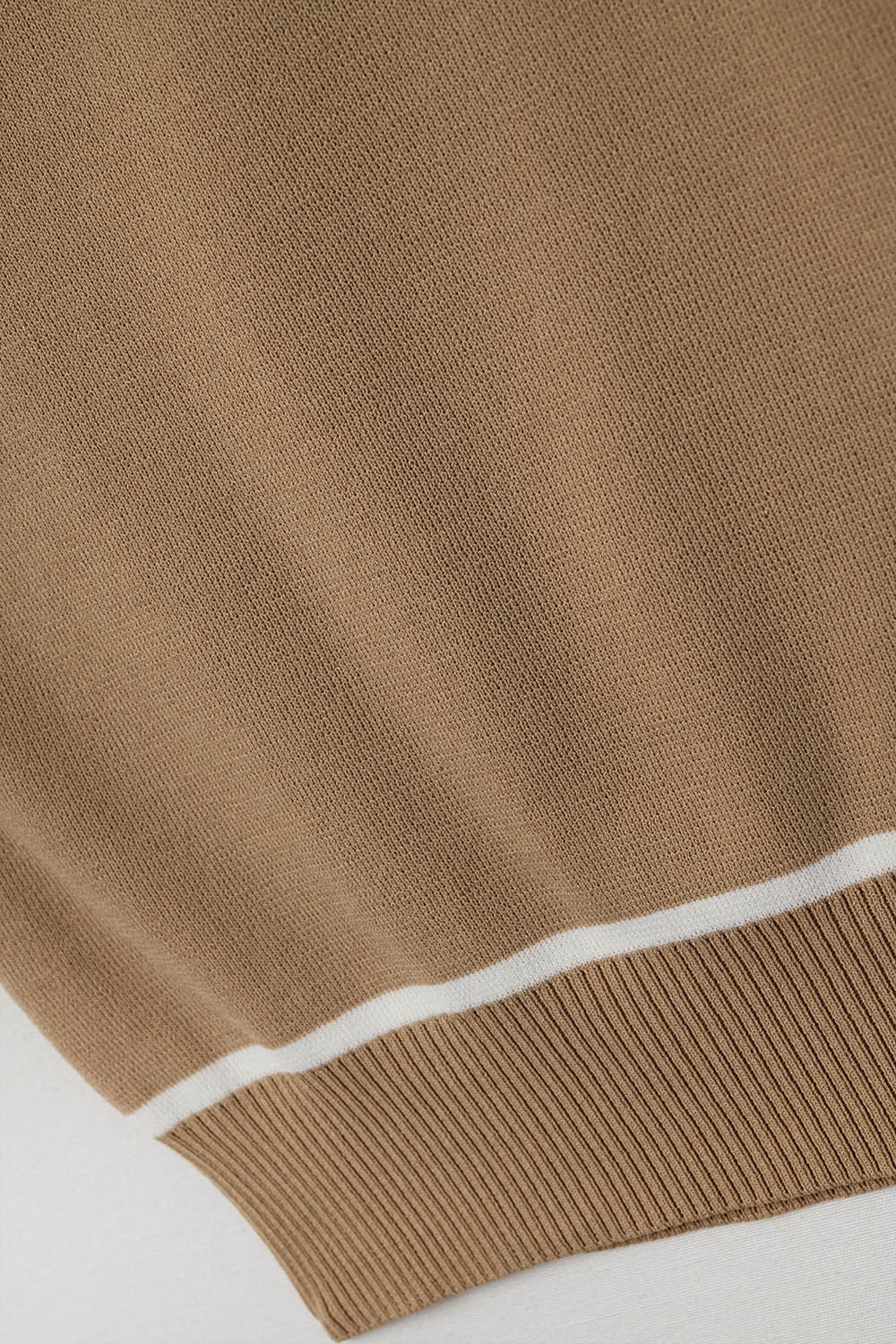 Suéter sin mangas en color camel con detalles de líneas blancas Suéter sin mangas en color camel con detalles de líneas blancas