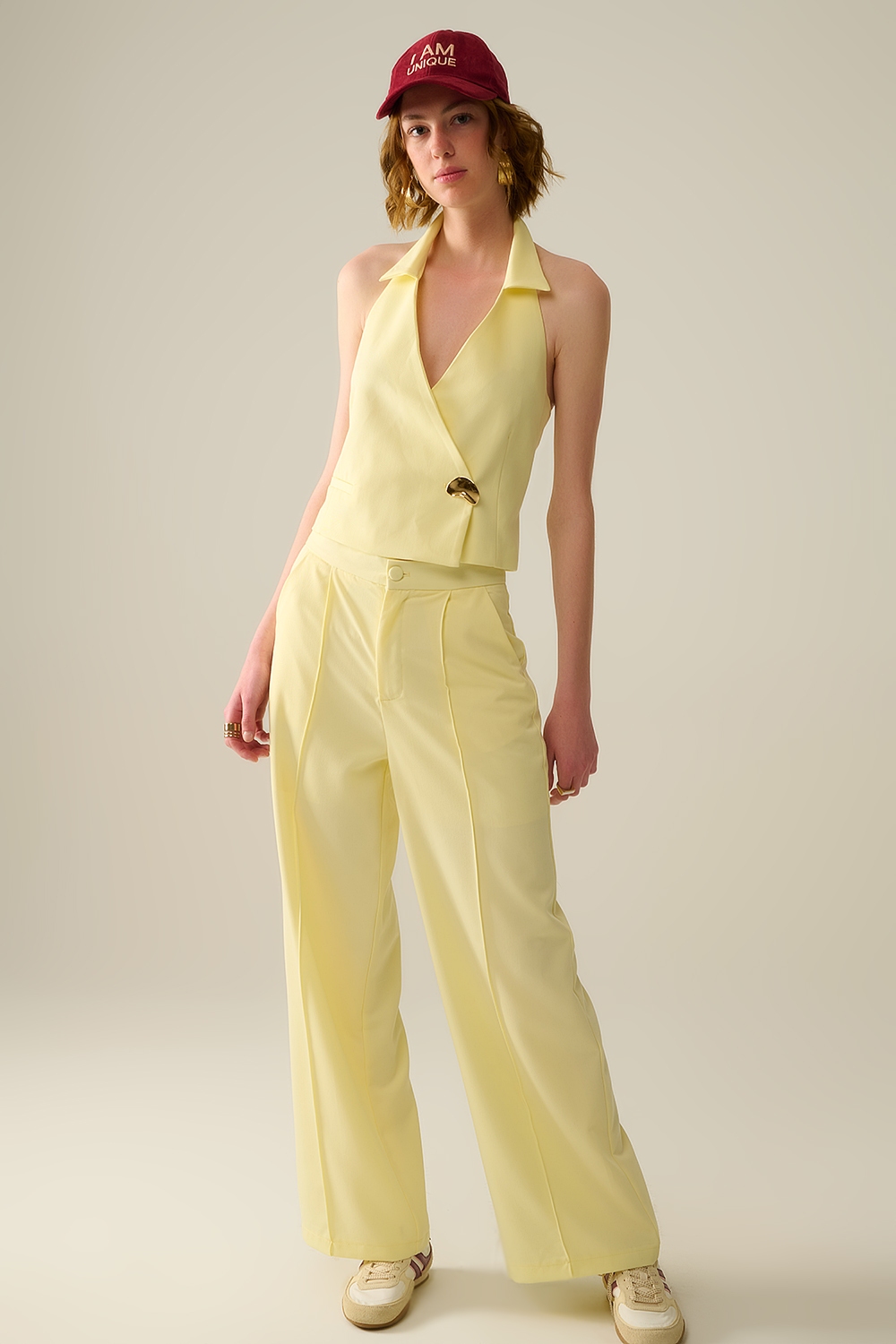 Chaleco envolvente amarillo con bot&oacute;n dorado detallado