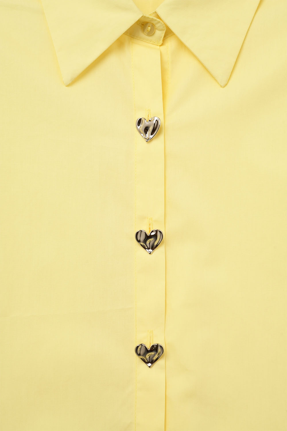 Blusa amarilla sin mangas con botones en forma de coraz&oacute;n