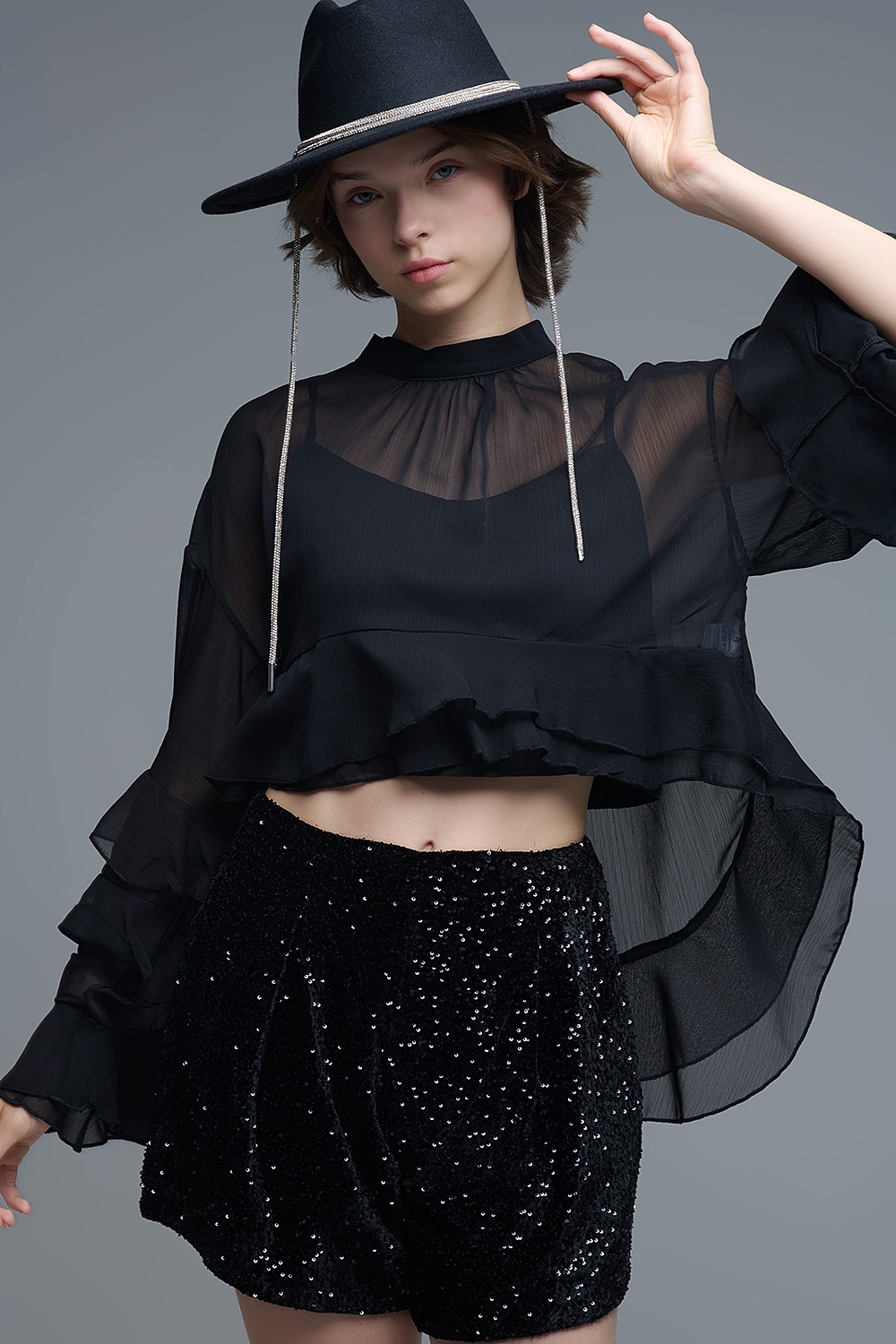 Blusa negra de gasa con volantes y transparencias estilo capa
