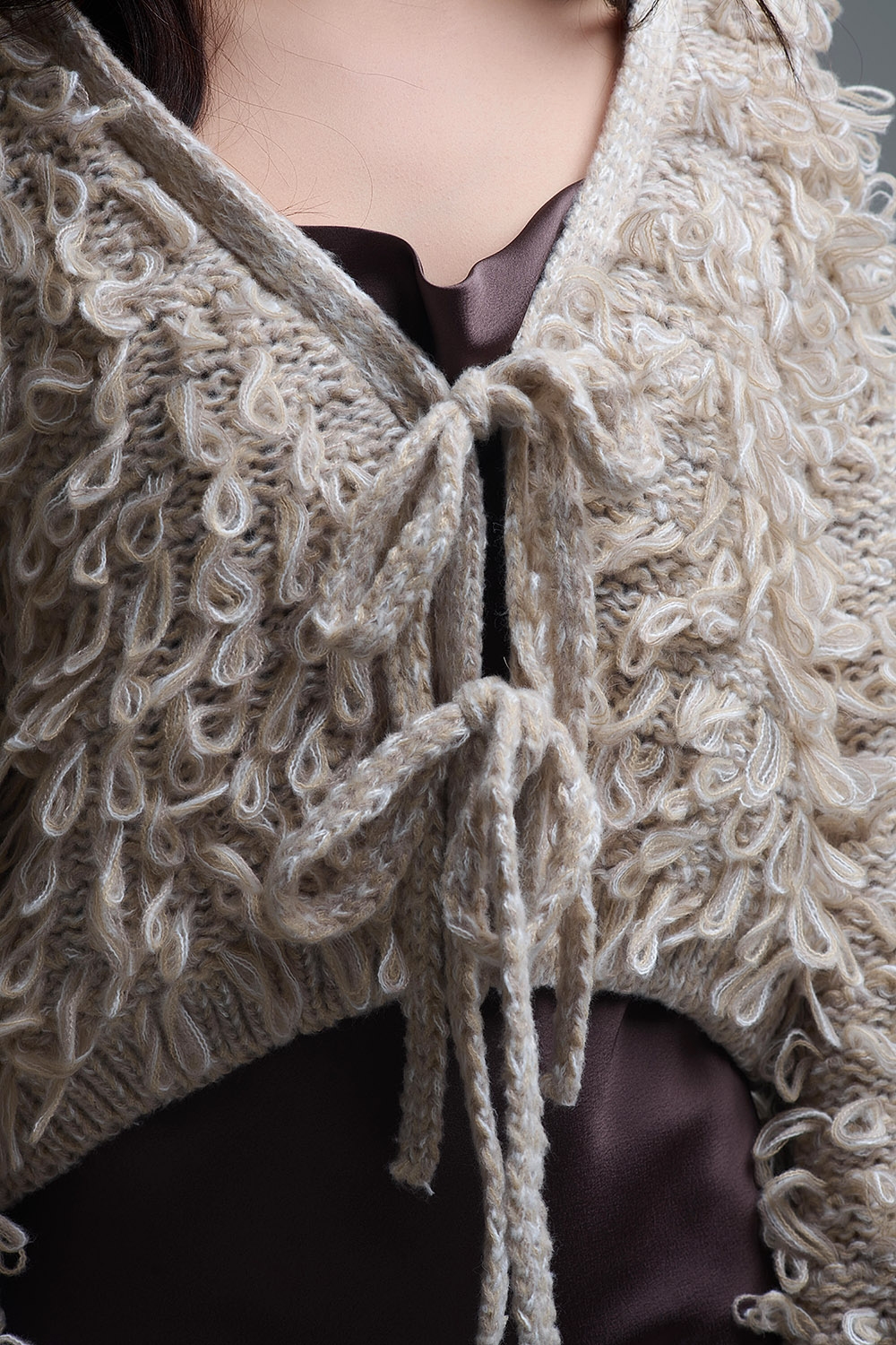 Chaqueta de punto grueso beige con cuello en V y cierre de lazo delantero