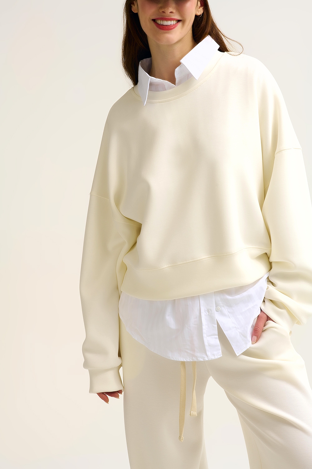 Sudadera b&aacute;sica con cuello redondo y hombros ca&iacute;dos en color crema