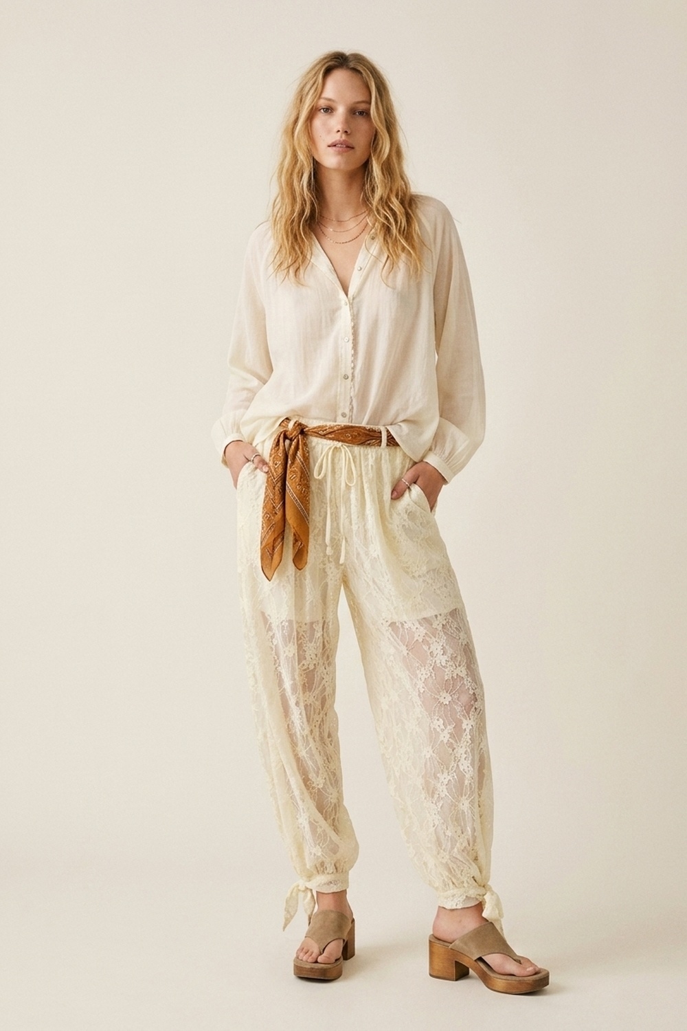 Pantalones de corte relajado con encaje floral color crema y bajo con lazo