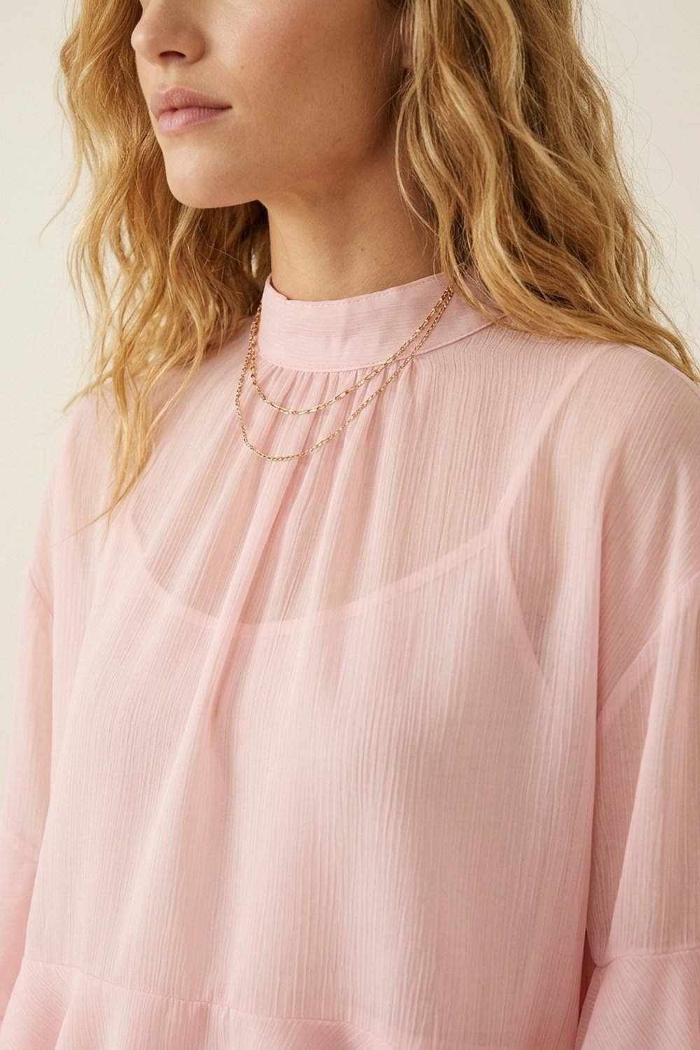 Blusa asim&eacute;trica con cuello alto y volantes de gasa rosa claro