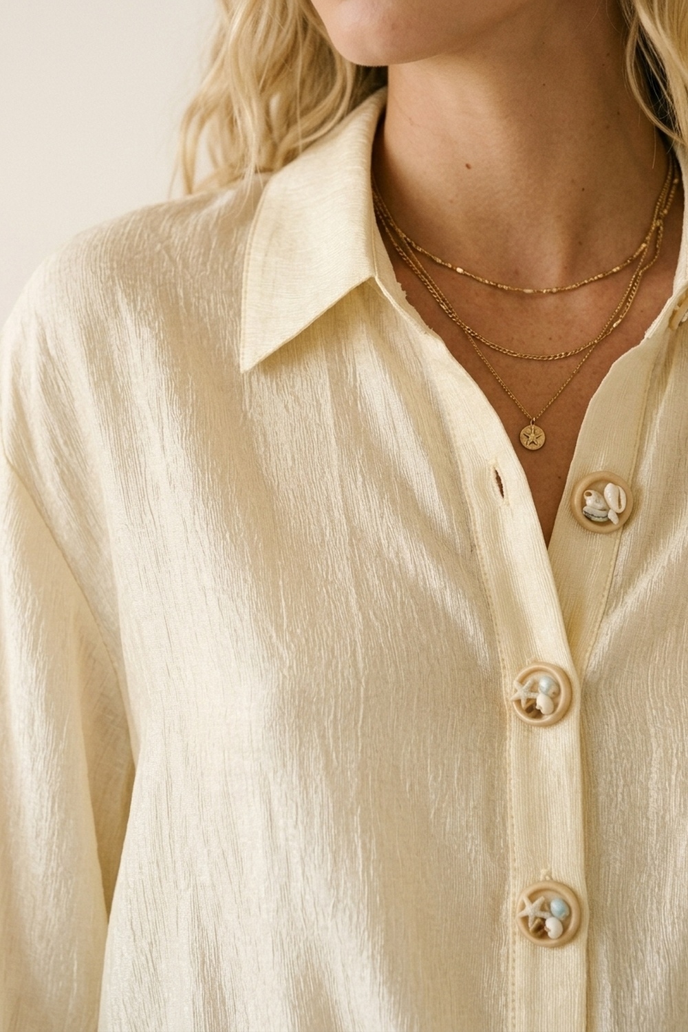 blusa beige de tela brillante con botones retro