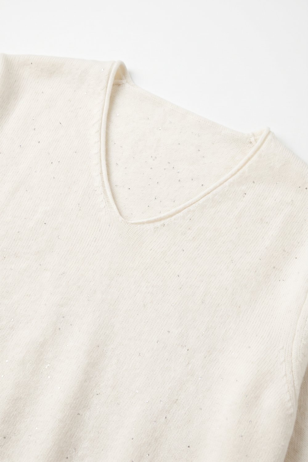 Su&eacute;ter de punto fino color crema con cuello en V ribete acanalado y lentejuelas adornadas
