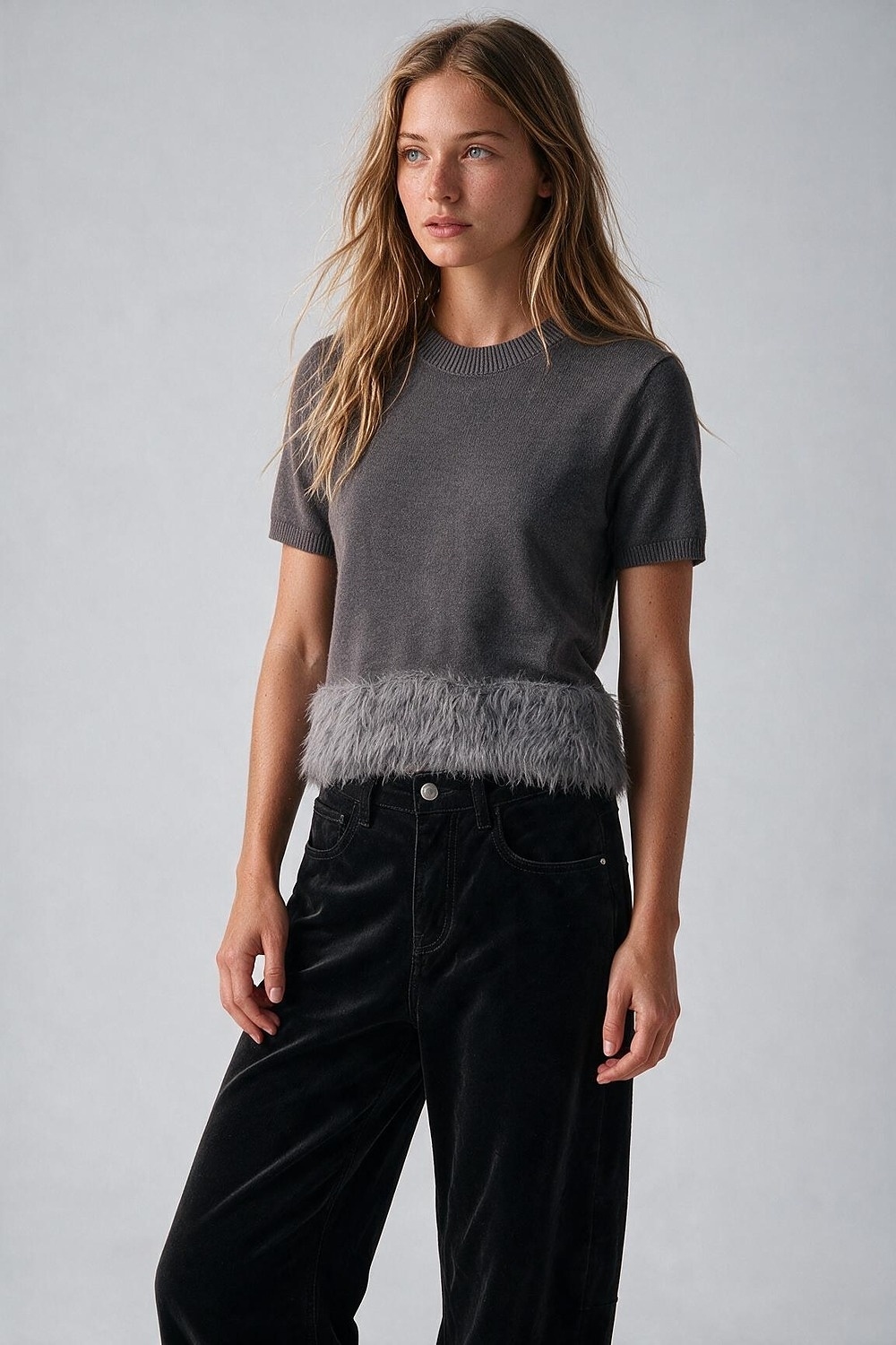 Suéter gris de punto fino con dobladillo de plumas y mangas cortas Suéter gris de punto fino con dobladillo de plumas y mangas cortas