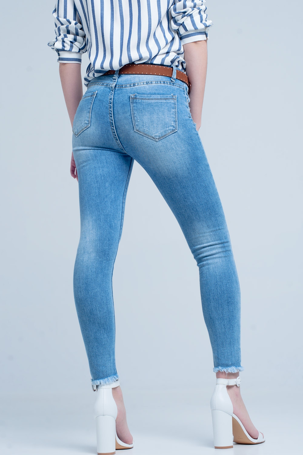 Vaqueros ajustados en azul con detalle rasgado