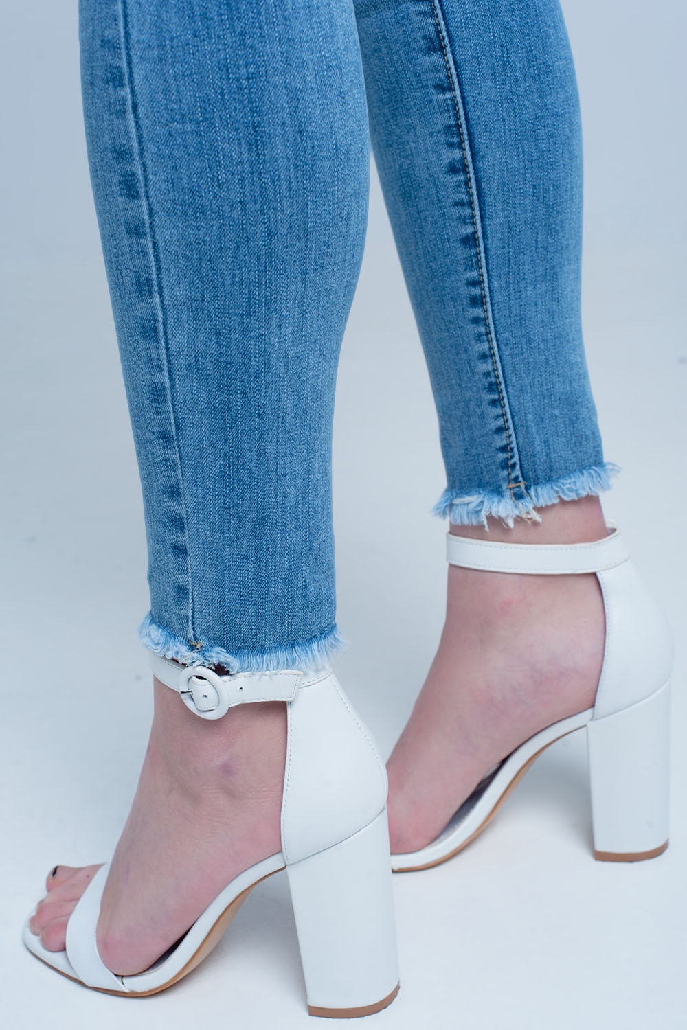 Vaqueros ajustados en azul con detalle rasgado