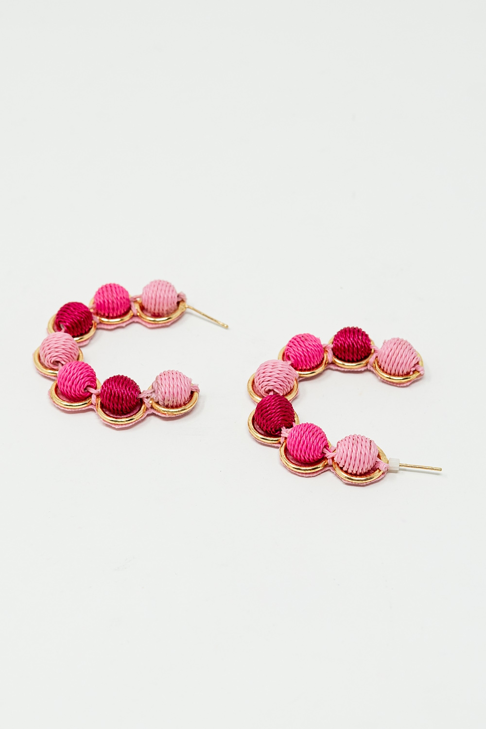 Pendiente de aro de oro con esferas de lana en rosa y fucsia